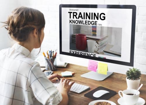 Instructor services illustrated by photo of a woman in front of a desktop computer, with the words training knowledge on the screen.